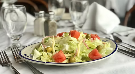 1905 Salad with Utensils on a table with a white table cloth