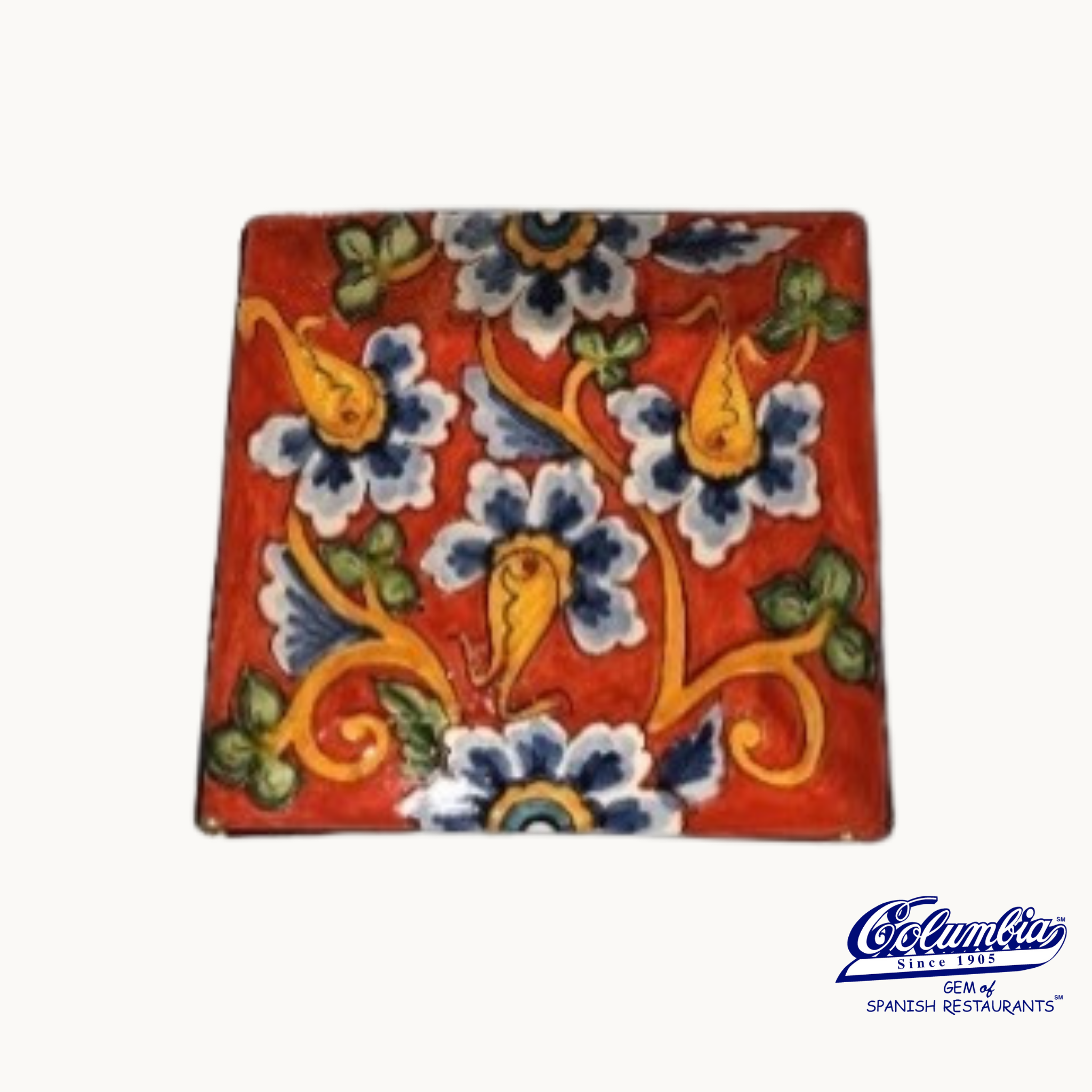 A small square red plate with a multicolor floral design, handcrafted with an Italian influence.
