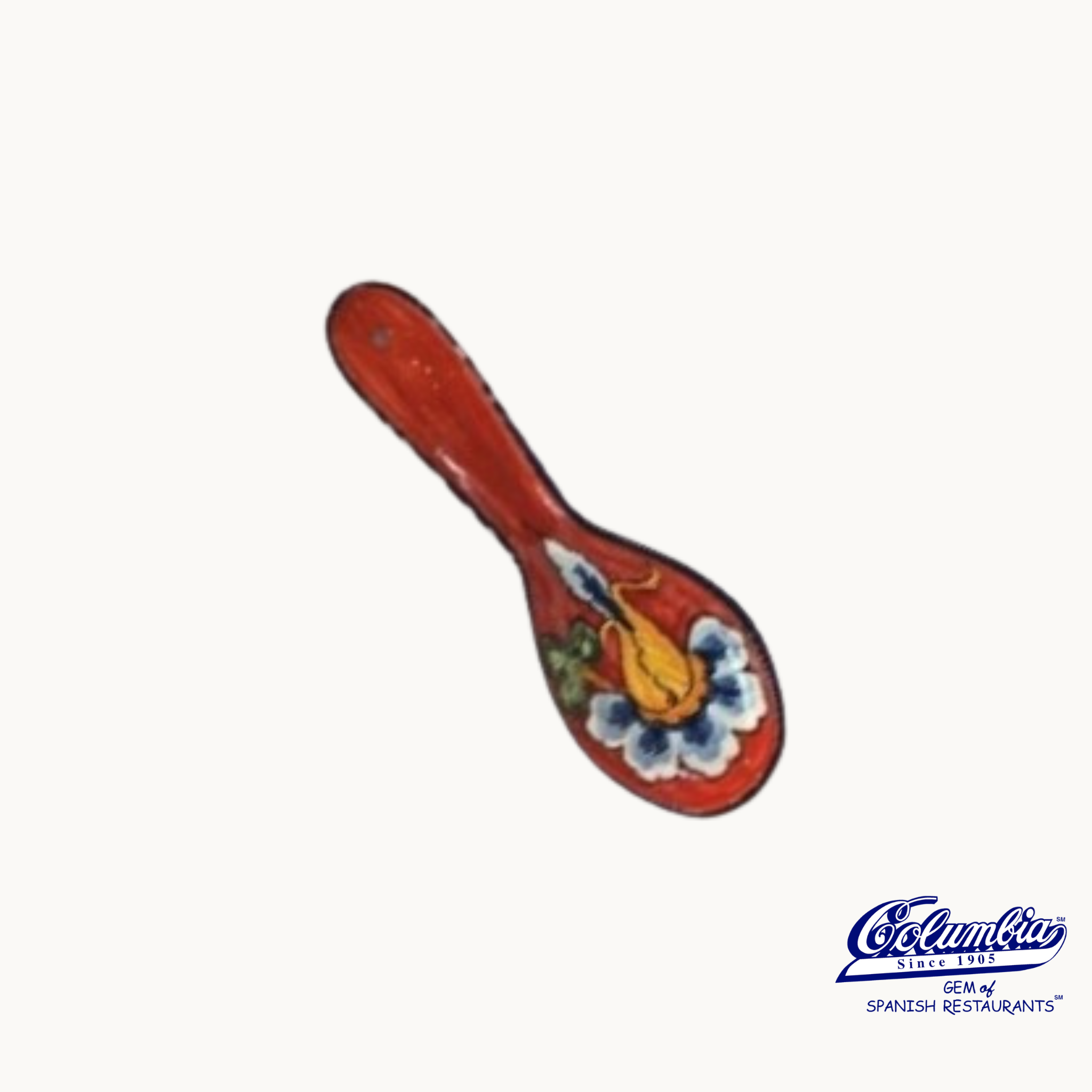 A red ceramic spoon rest with a multicolor flower design.