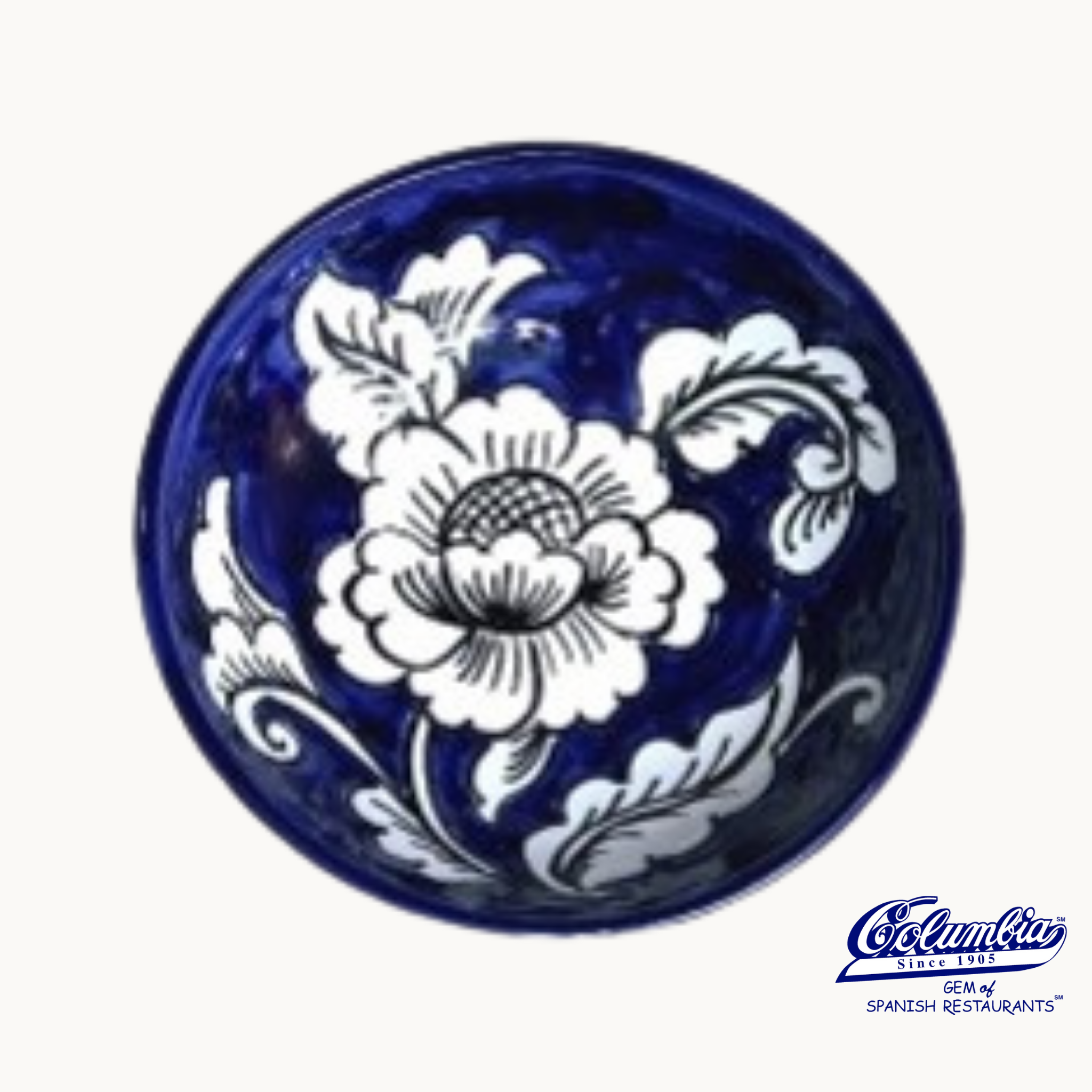 A handcrafted blue and white ceramic bowl with a gardenia pattern, featuring a prominent floral design.