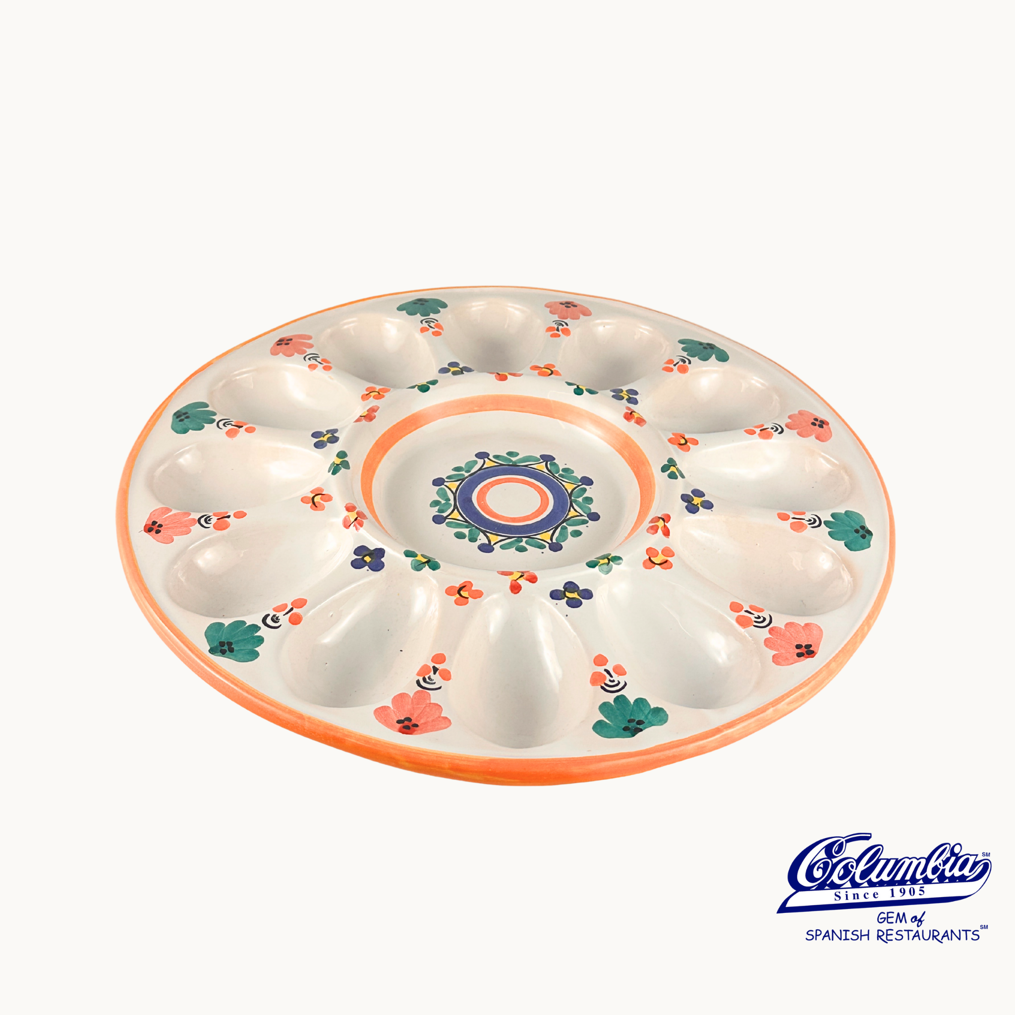 Decorative ceramic plate with floral patterns on a white background, featuring the Cocinilla logo.