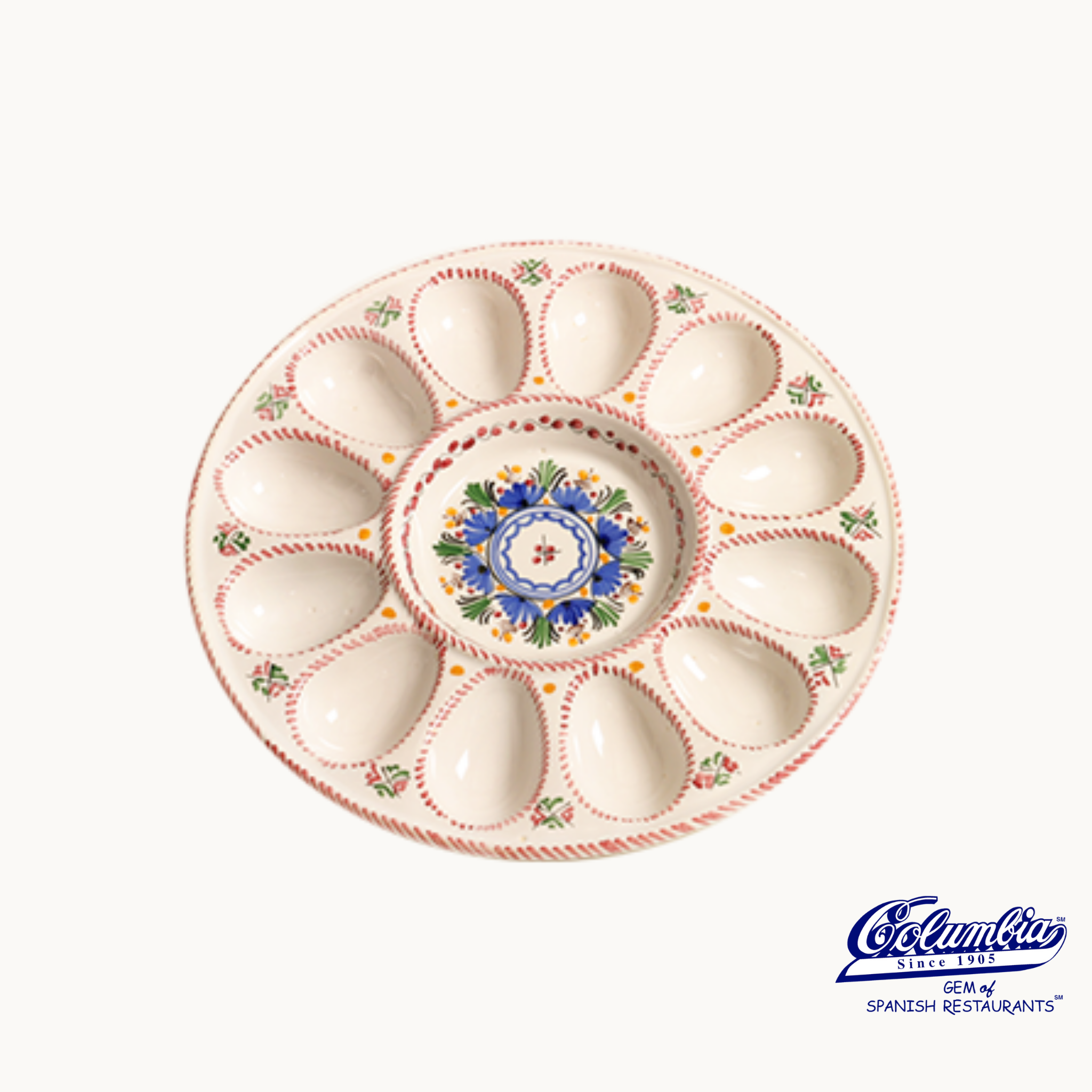 A colorful ceramic serving platter designed for deviled eggs with a central condiment well, hand-painted with a floral and geometric pattern.