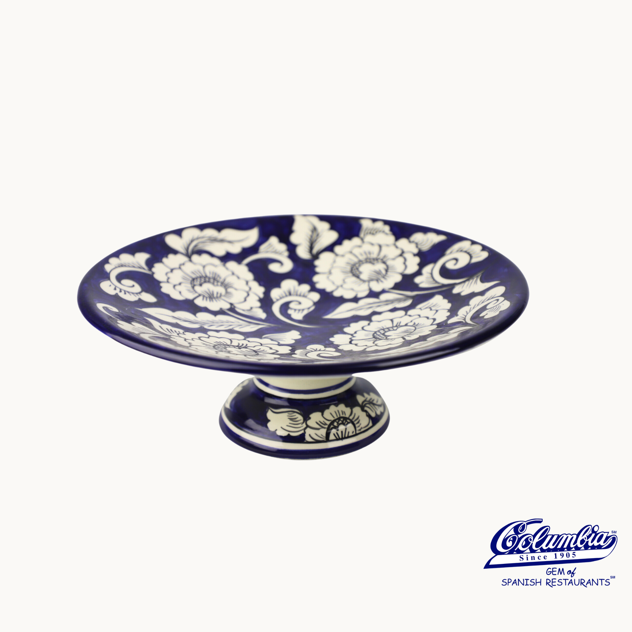 Ceramic cake stand with floral patterns on a white background