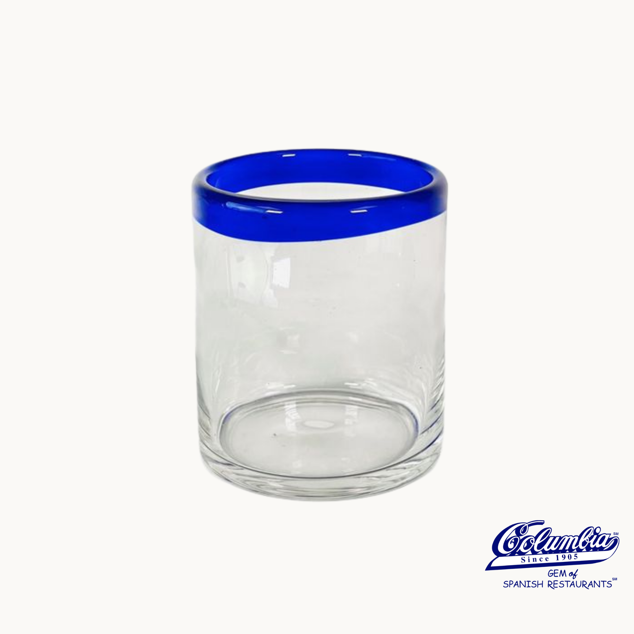 A small mojito glass with a blue rim on a white background, with the Columbia restaurant logo.