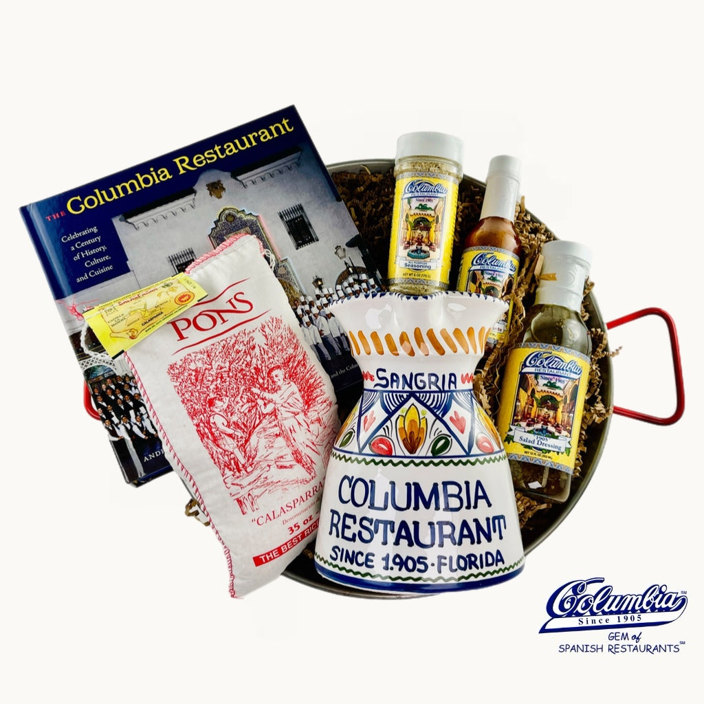 Collection of Columbia Restaurant items including a bottle, a book, and a bag on a white background.