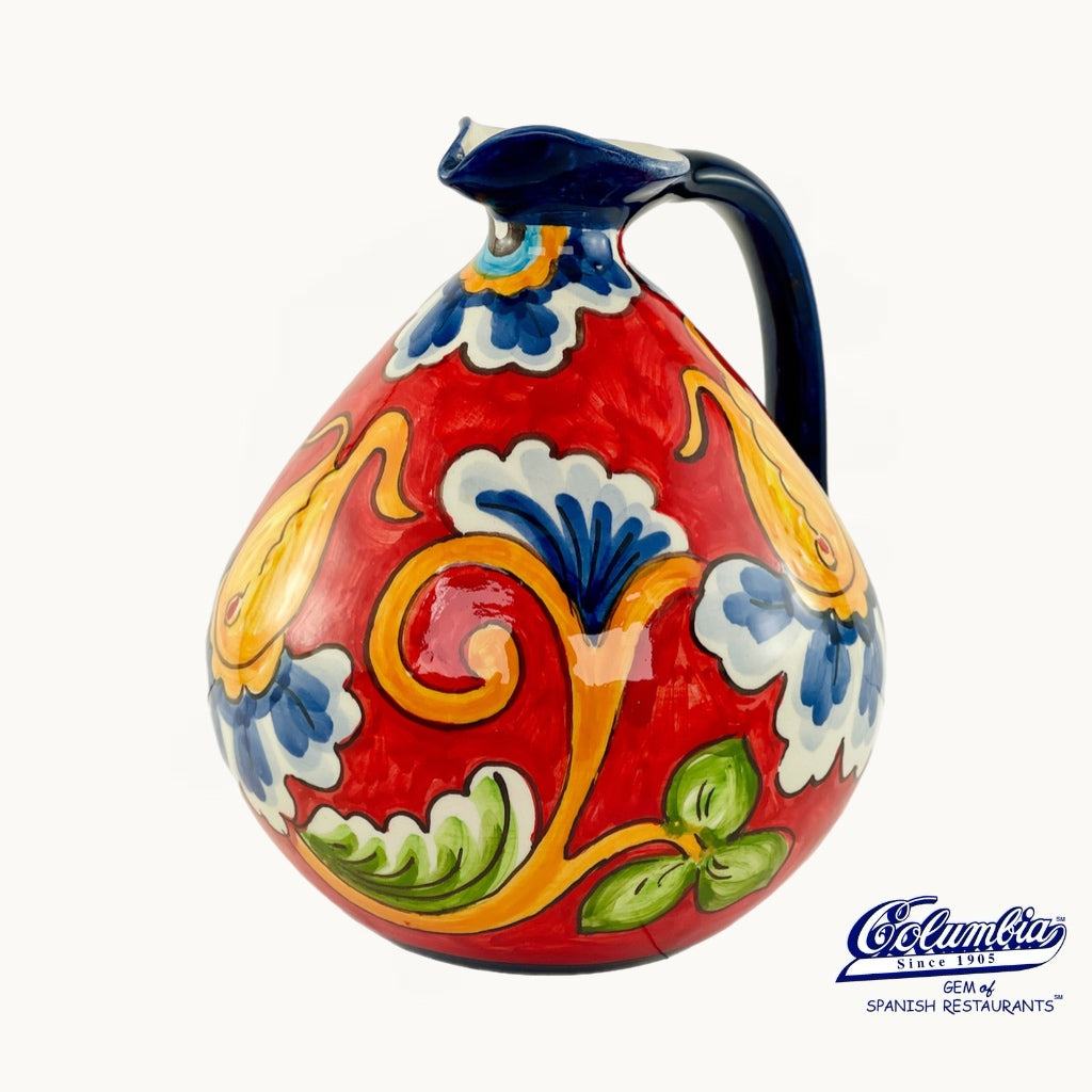Colorful ceramic pitcher with floral patterns on a white background