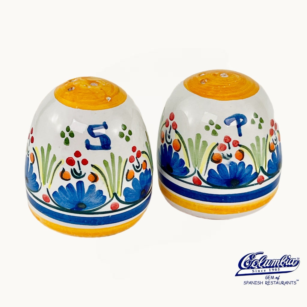 Colorful ceramic salt and pepper shakers with floral designs on a white background, featuring the Colman's brand.