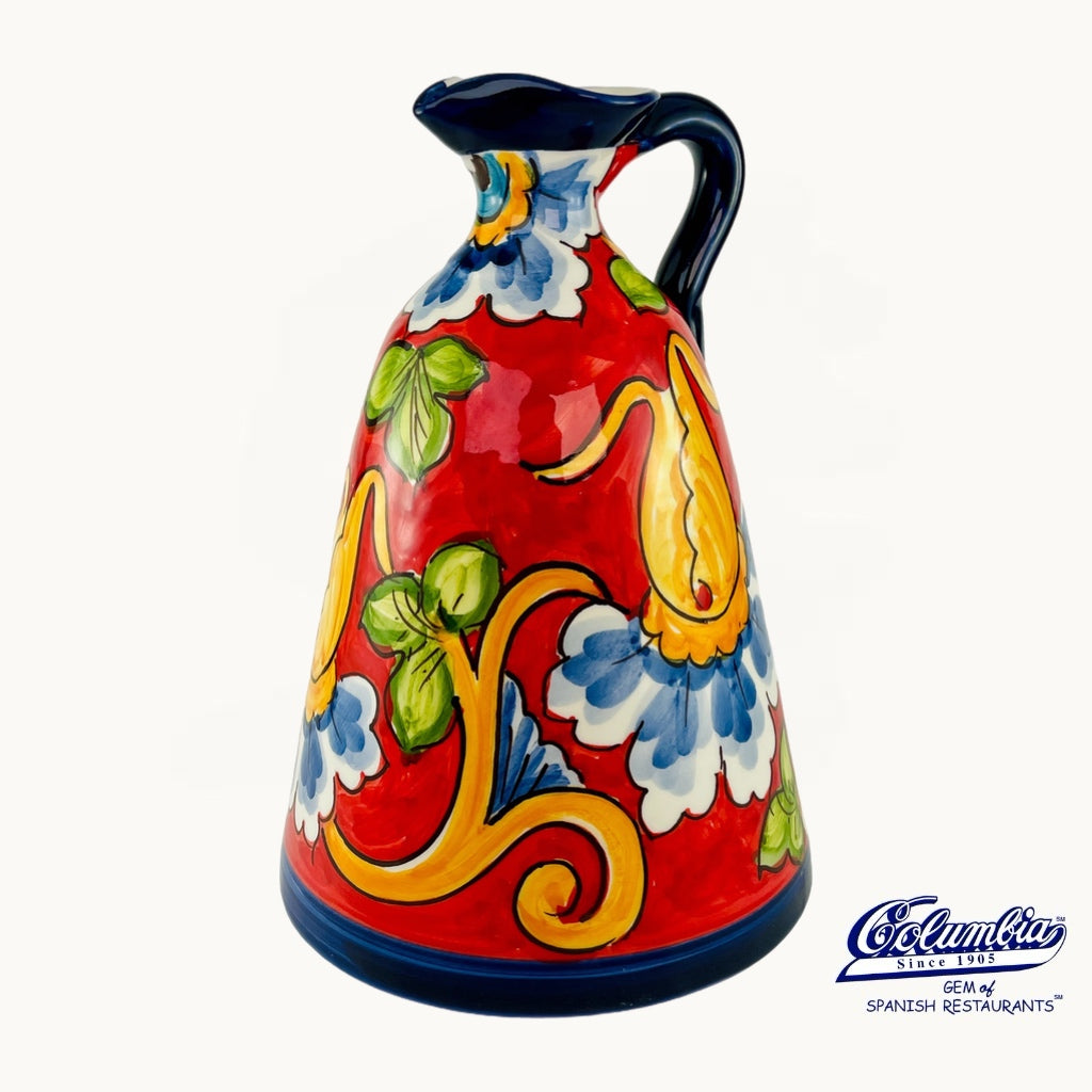 Colorful ceramic pitcher with floral designs on a white background