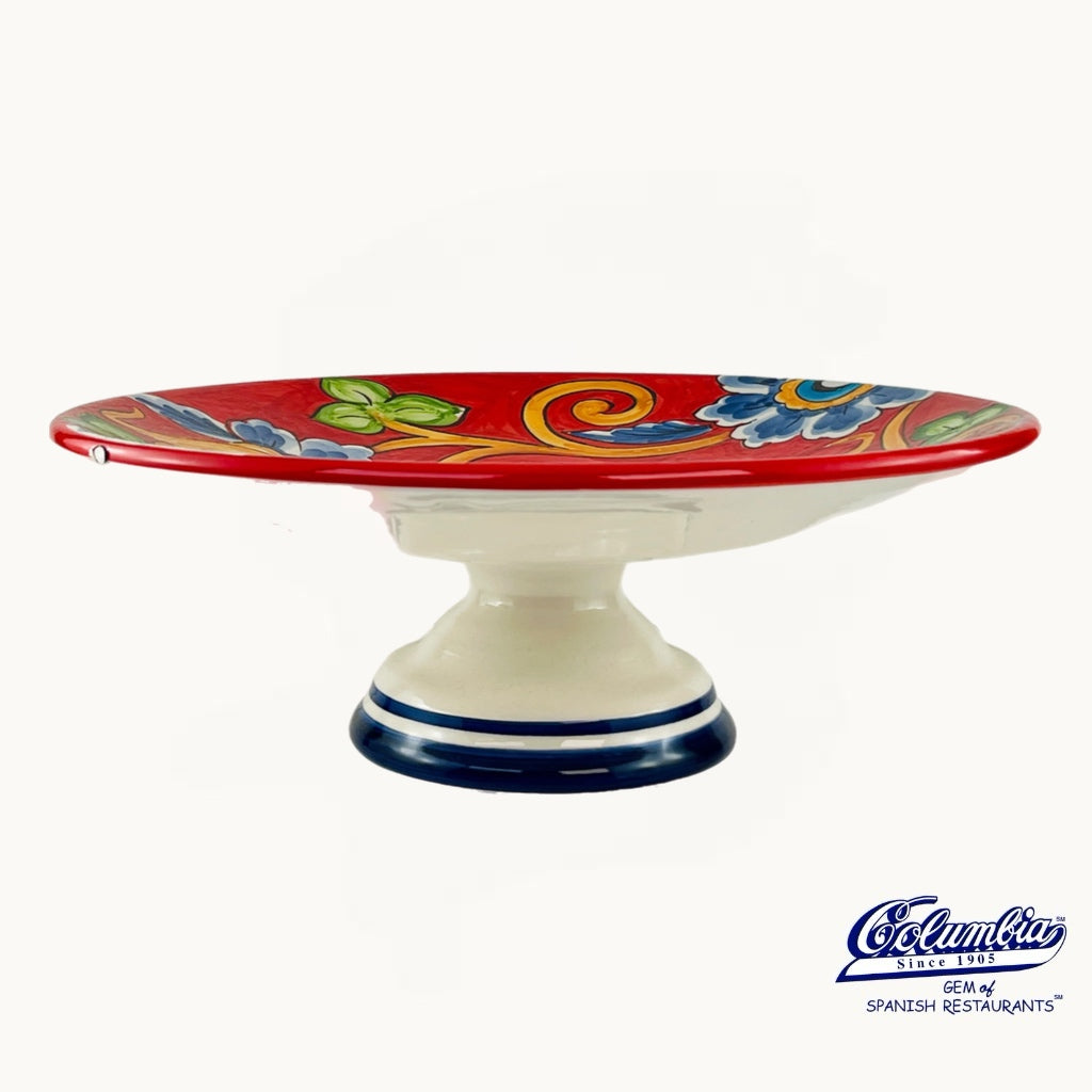 Decorative ceramic cake stand with colorful design on a white background