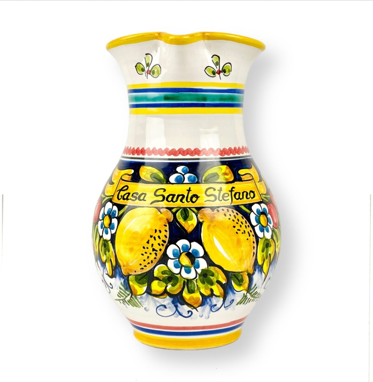 A hand-painted, ceramic large pitcher with floral and fruit patterns, predominantly yellow and white, with the text 'Casa Santo Stefano' on it.