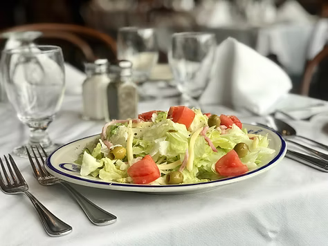1905 Salad with Utensils on a table with a white table cloth