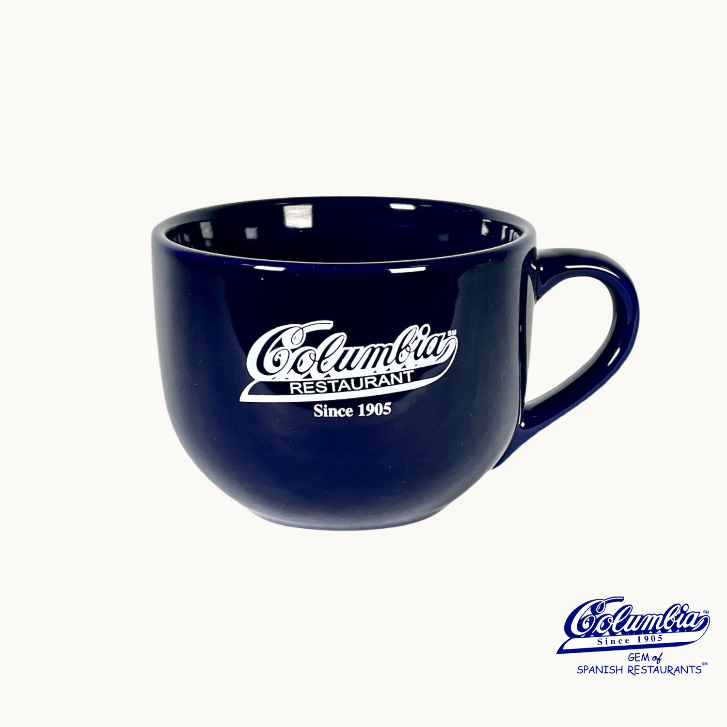 A blue ceramic cappuccino mug with the Columbia Restaurant logo printed on it.
