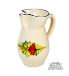 A ceramic serving pitcher with a floral design and blue trim on the rim, imported from Italy.