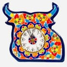 Colorful hand-painted ceramic bull-shaped wall clock with floral patterns in red, orange, yellow, green, and blue, featuring a round clock face in the center