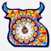 Colorful hand-painted ceramic bull-shaped wall clock with floral patterns in red, orange, yellow, green, and blue, featuring a round clock face in the center