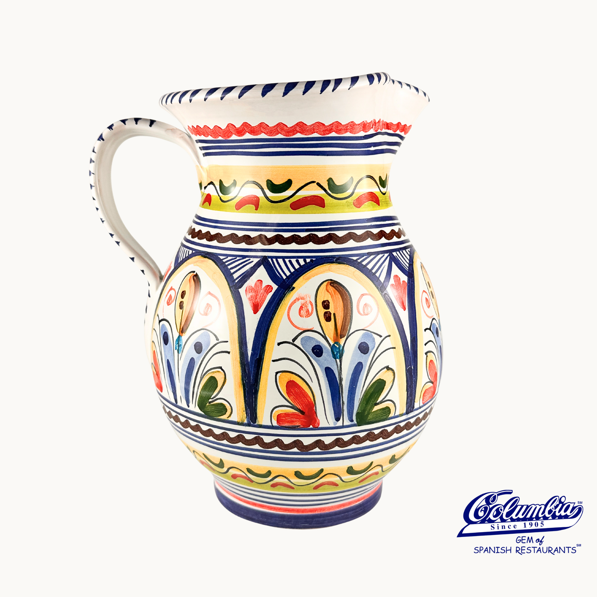 Colorful ceramic pitcher with floral patterns on a white background, featuring the Columba brand.