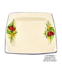 Casa Santo Stefano square ceramic plate with cream background, hand-painted floral designs in red, yellow, and green on two corners, and blue trim around the edges.