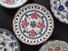 A collection of ceramic coasters with floral and geometric patterns in various colors.
